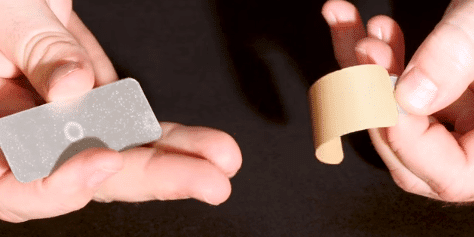 Adhesive Backing Being Removed from Metal Tag Adhesive Backing Being Removed from Metal Tag