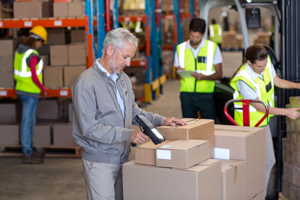 Manager is scanning the barcode labels on the boxes.