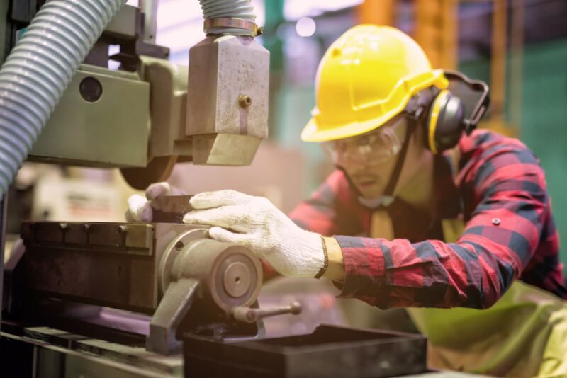 A young worker using machinery. Machinery tags is not only important for identification but also important for safety when using different machineries.